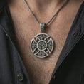 Load image into Gallery viewer, Oxidized Celtic cross pendant necklace worn on the chest, close-up lifestyle jewelry photo showing the Norse knotwork cross on a spiga chain with dark clothing.