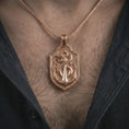Load image into Gallery viewer, Rose gold plated serpent and anchor pendant necklace worn on the chest, close-up lifestyle shot featuring the serpent and anchor design with warm rose gold tones.