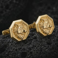 Load image into Gallery viewer, Gold plated wolf head cufflinks sit on textured volcanic rock in a dramatic studio macro shot, highlighting the bold animal motif and formal accessory design.