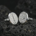 Load image into Gallery viewer, Polished silver Saint Michael cufflinks on textured volcanic rock, centered macro jewelry photo with detailed guardian angel medal engraving and bright silver highlights.
