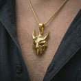 Load image into Gallery viewer, A gold plated Loki pendant is worn on the neck in a close-up lifestyle shot, styled as a powerful Viking mythology gift for men.