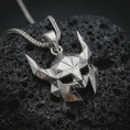 Load image into Gallery viewer, A polished silver Helm of Awe inspired mask pendant is displayed on black volcanic rock in a premium macro studio close-up with sharp geometric details.