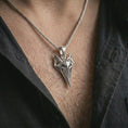 Load image into Gallery viewer, A polished silver Freyja cat pendant is worn on the neck in a premium close-up lifestyle image, showing the faceted feline symbol clearly.
