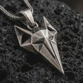 Load image into Gallery viewer, An oxidized Freyja cat pendant rests on dark volcanic rock in a macro studio close-up, showing a faceted feline design inspired by Norse mythology.