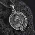 Load image into Gallery viewer, Oxidized Aries zodiac pendant necklace on textured volcanic rock, close-up studio shot highlighting the ram relief, sun detail, Aries symbol, and antique silver contrast.