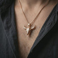 Load image into Gallery viewer, Rose gold plated bull skull pendant necklace worn on the chest, close-up lifestyle shot featuring the rugged bull skull design with warm rose gold tones.