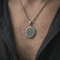Load image into Gallery viewer, Oxidized Vegvisir Viking rune pendant necklace worn on the chest, close-up lifestyle jewelry photo showing the Norse compass medallion on a spiga chain with dark clothing.