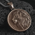 Load image into Gallery viewer, Bronze Lion of Judah pendant necklace on textured volcanic rock, close-up studio shot highlighting the lion profile, flowing mane, sunburst background, and antique silver contrast.