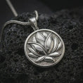 Load image into Gallery viewer, Polished silver lotus flower pendant necklace on textured volcanic rock, centered macro jewelry photo with detailed petal relief and bright silver highlights.