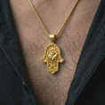 Load image into Gallery viewer, Gold plated hamsa hand pendant necklace worn on the chest, premium lifestyle jewelry photo with the hamsa evil eye pendant centered on a spiga chain.