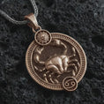 Load image into Gallery viewer, Bronze Cancer zodiac pendant necklace on textured volcanic rock, close-up studio shot highlighting the crab relief, sun detail, Cancer symbol, and antique silver contrast.
