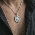 Load image into Gallery viewer, Polished silver Cancer zodiac pendant necklace worn on the chest, masculine lifestyle shot highlighting the crab relief, sun detail, and bright silver finish.