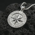 Load image into Gallery viewer, Polished silver Greek compass pendant necklace on textured volcanic rock, centered macro jewelry photo with detailed directional star relief and bright silver highlights.
