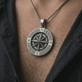 Load image into Gallery viewer, Oxidized Greek compass pendant necklace worn on the chest, close-up lifestyle jewelry photo showing the navigation medallion on a spiga chain with dark clothing.