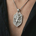 Load image into Gallery viewer, Polished silver heraldic lion shield pendant necklace worn on the chest, masculine lifestyle shot highlighting the bright silver finish, shield silhouette, and sculpted rampant lion relief.