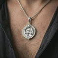 Load image into Gallery viewer, Polished silver Scorpio zodiac pendant necklace worn on the chest, masculine lifestyle shot highlighting the scorpion relief, sun detail, and bright silver finish.