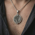 Load image into Gallery viewer, Oxidized Scorpio zodiac pendant necklace worn on the chest, close-up lifestyle jewelry photo showing the scorpion astrology medallion on a spiga chain with dark clothing.