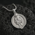 Load image into Gallery viewer, Polished silver Leo zodiac pendant necklace on textured volcanic rock, centered macro jewelry photo with detailed lion horoscope relief and bright silver highlights.