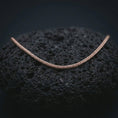 Load image into Gallery viewer, A rose gold plated foxtail chain necklace is photographed on porous volcanic rock in a close-up studio composition with refined luxury lighting and smooth chain texture.
