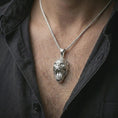 Load image into Gallery viewer, A polished silver gorilla pendant is worn on the neck in a premium close-up lifestyle image, showing the roaring ape face clearly.