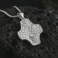 Load image into Gallery viewer, A polished silver Tree of Life cross pendant is displayed on black volcanic rock in a premium macro studio close-up with detailed leaves and flowing branch texture.