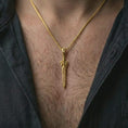 Load image into Gallery viewer, A gold plated fantasy sword pendant is worn on the neck in a close-up lifestyle shot, styled as a meaningful dark fantasy gift for men.