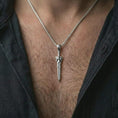 Load image into Gallery viewer, A polished silver fantasy sword pendant is worn on the neck in a premium close-up lifestyle image, showing the long blade silhouette clearly.