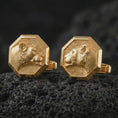 Load image into Gallery viewer, Gold plated lioness head cufflinks sit on textured volcanic rock in a dramatic studio macro shot, highlighting the elegant animal motif and formal accessory design.