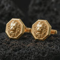 Load image into Gallery viewer, Gold plated lion head cufflinks sit on textured volcanic rock in a dramatic studio macro shot, highlighting the powerful animal motif and formal accessory design.