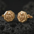 Load image into Gallery viewer, Gold plated octopus cufflinks sit on textured volcanic rock in a dramatic studio macro shot, highlighting the nautical animal motif and formal accessory design.