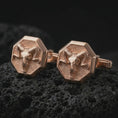 Load image into Gallery viewer, Rose gold plated ram skull cufflinks are photographed on porous volcanic rock in a close-up studio composition with refined luxury lighting and gothic animal detail.