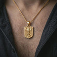 Load image into Gallery viewer, Gold plated German eagle shield pendant necklace worn on the chest, premium lifestyle jewelry photo with the eagle shield pendant centered on a spiga chain.
