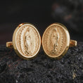 Load image into Gallery viewer, Gold plated Our Lady of Guadalupe cufflinks sit on textured volcanic rock in a dramatic studio macro shot, highlighting the sacred Virgin Mary design.