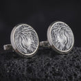 Load image into Gallery viewer, An oxidized Jesus Crown of Thorns cufflink pair rests on dark volcanic rock in a macro studio close-up, showing a detailed Christ portrait inside round frames.