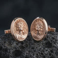 Load image into Gallery viewer, Rose gold plated Jesus Crown of Thorns cufflinks are photographed on porous volcanic rock in a close-up studio composition with refined luxury lighting and religious detail.