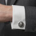 Load image into Gallery viewer, An oxidized lion head cufflink is worn on a white shirt cuff in a close-up lifestyle shot, styled with a dark suit for a bold formal look.