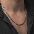 Load image into Gallery viewer, Oxidized Greek key chain necklace is worn on the neck in a close-up lifestyle shot, styled as a masculine everyday silver necklace.