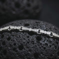Load image into Gallery viewer, Polished silver Greek key chain necklace is displayed on black volcanic rock in a premium macro studio close-up with clean geometric link details.