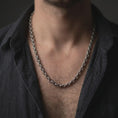 Load image into Gallery viewer, Oxidized ornamental silver chain worn close to the neck on a male model, styled as a detailed standalone men’s necklace.