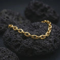 Load image into Gallery viewer, Gold plated mariner link bracelet resting on black lava rock, designed with bold nautical-inspired chain links.