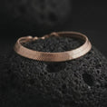 Load image into Gallery viewer, Rose gold plated herringbone bracelet displayed on black lava stone, combining a warm finish with a minimal flat chain silhouette.