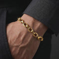 Load image into Gallery viewer, Gold plated Greek key bracelet worn closely around a man’s wrist, emphasizing the repeating eternity pattern and articulated chain construction in a premium lifestyle shot.