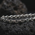 Load image into Gallery viewer, Oxidized sterling silver ornamental link chain displayed on black volcanic rock, showing raised circular details and dark antique recesses.