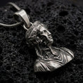 Load image into Gallery viewer, Oxidized architectural bust pendant resting on volcanic rock in dark macro studio close-up