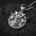 Load image into Gallery viewer, The polished silver samurai pendant is displayed on textured volcanic rock, highlighting the sculpted warrior face, engraved helmet crest, layered armor, and dimensional Japanese details in a premium macro photograph.