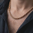 Load image into Gallery viewer, The rose gold plated ridged barrel necklace is worn naturally on a man’s chest, showcasing the cylinder link structure, polished surfaces, and refined masculine jewelry design.