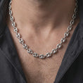 Load image into Gallery viewer, The polished silver 11mm mariner necklace is worn on a man’s chest, showing its substantial oval links and structured central-bar design in a detailed lifestyle photograph.