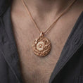 Load image into Gallery viewer, The rose gold plated Bagua pendant is worn on a man’s chest, showcasing the sculpted dragon, ornamental phoenix, central Yin Yang emblem, and dimensional circular frame in an elegant lifestyle shot.