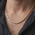 Load image into Gallery viewer, The rose gold plated ornate chain necklace is worn naturally on a man’s chest, showcasing the flowing scroll engravings, flexible link construction, and masculine jewelry design.