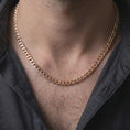 Load image into Gallery viewer, The rose gold plated Cuban chain necklace is worn naturally on a man’s chest, showcasing the flexible interlocking links, warm finish, and elegant masculine jewelry design.